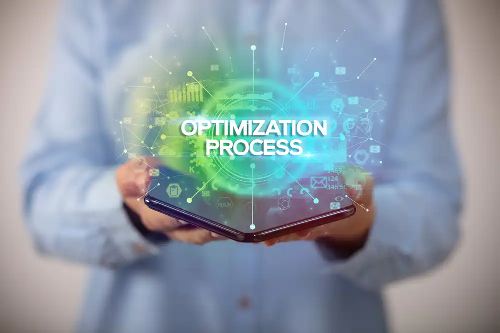Person holding a smartphone with a glowing digital hologram displaying the text Optimization Process and various data icons